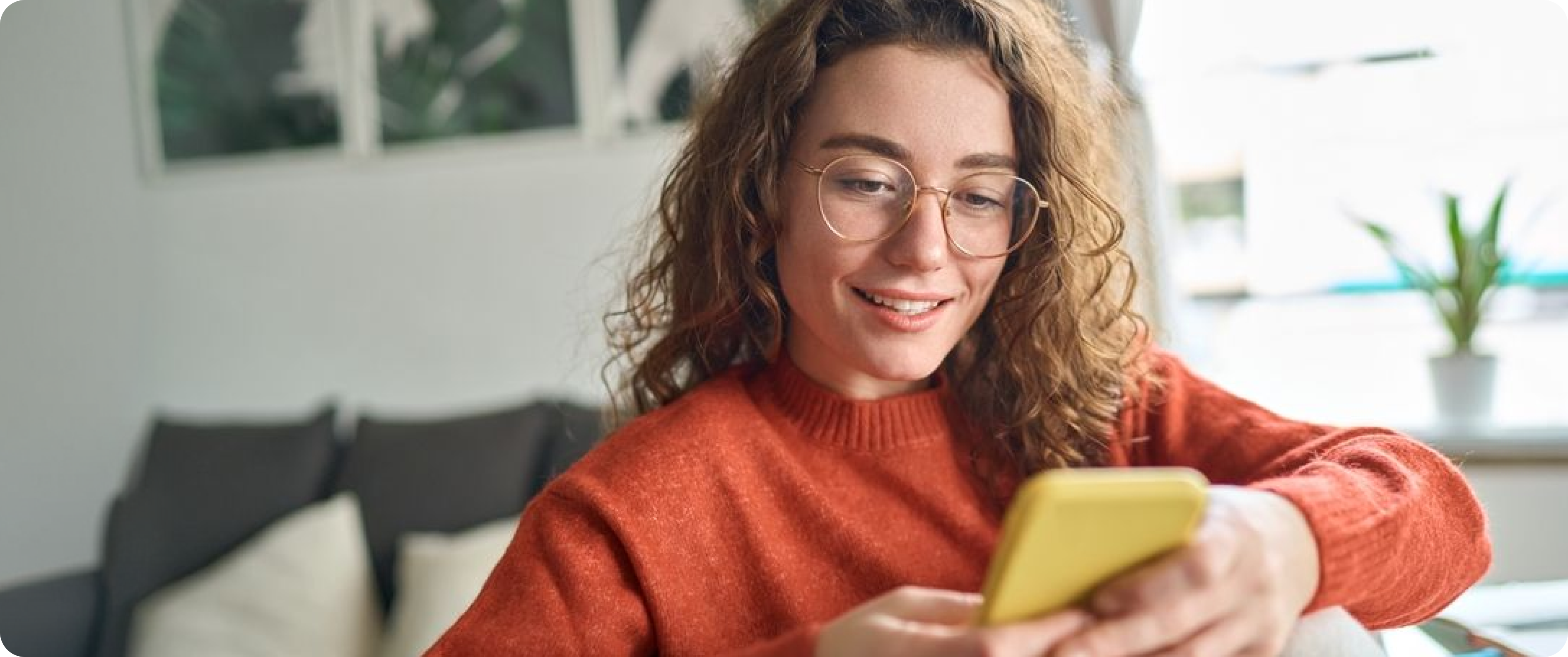 Woman holding a phone while sitting indoors